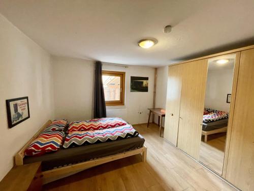 a bedroom with a bed and a mirror at Adventure Holiday Hub: Gartenhäusl in Mayrhofen