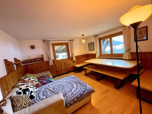 Habitación con cama, escritorio y mesa. en Adventure Holiday Hub: Gartenhäusl en Mayrhofen