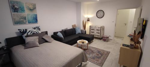 a bedroom with a bed and a couch and a clock at Perle im Zentrum von MG / Minto in Mönchengladbach