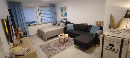 ein Wohnzimmer mit einem Sofa und einem Bett in der Unterkunft Perle im Zentrum von MG / Minto in Mönchengladbach