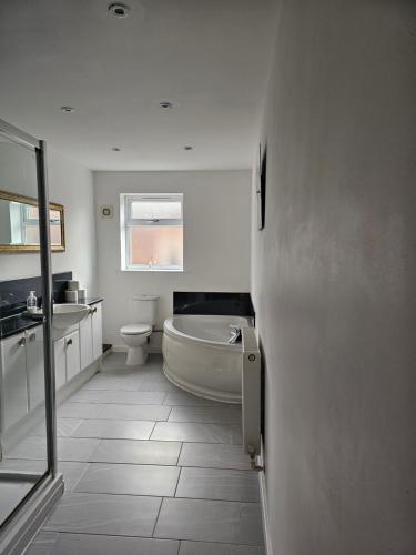 La salle de bains est pourvue d'une baignoire, de toilettes et d'un lavabo. dans l'établissement Luxury Home with Hot Tub BBQ Pool Table, à Chesterfield