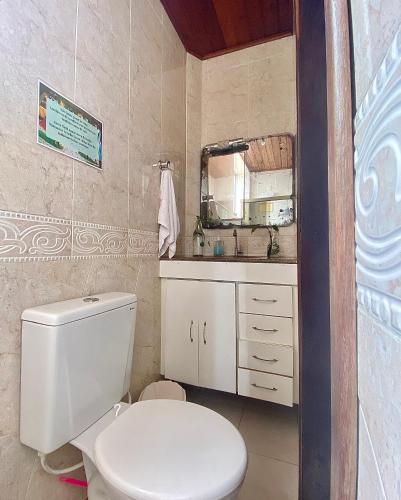 a bathroom with a white toilet and a sink at CasAMARelo Hostel in Salvador