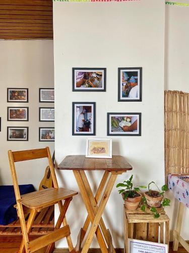 a table and a chair in a room with pictures on the wall at CasAMARelo Hostel in Salvador