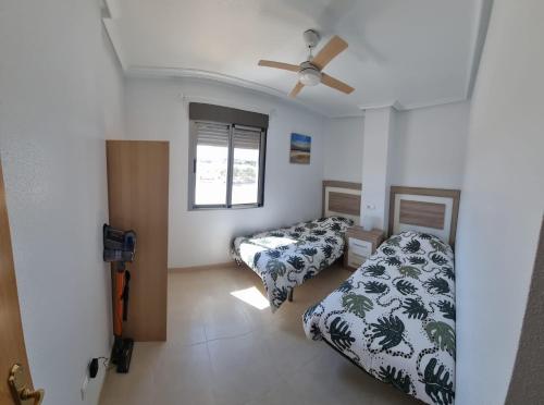 1 dormitorio con 2 camas y ventilador de techo en Carpediem in Spanje, en San Miguel de Salinas