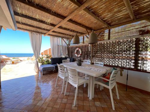 une salle à manger avec une table et des chaises et l'océan dans l'établissement The Lodge by the sea, à Ischia
