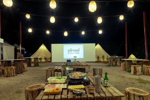 a table with food and a screen with tents at Today's Camp Khaokho ทูเดย์แคมป์เขาค้อ in Khao Kho