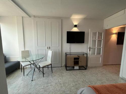 een woonkamer met een tafel en een televisie bij Luceros 310 New in Alicante