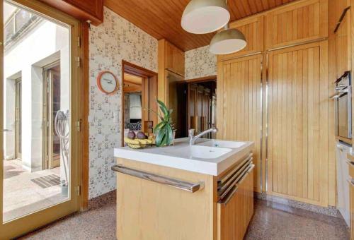 uma cozinha com um lavatório e uma grande janela em Villa des Oliviers em Fontenay-sous-Bois