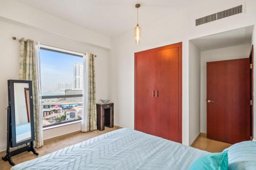 1 dormitorio con cama y ventana grande en Stunning 4-Bed Seaside Apartment - Your Perfect Ocean View Retreat!, en Dubái