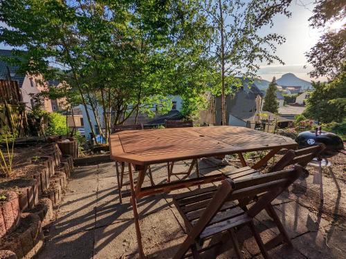 un tavolo da picnic in legno, posto accanto a una panchina. di Urlaubsmagie - Helle Wohnung mit Garten & Pool - R3 a Rathmannsdorf