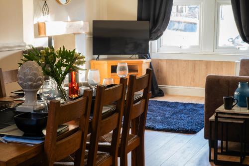 a dining room with a table with wine glasses on it at Orme Lodge in Llandudno