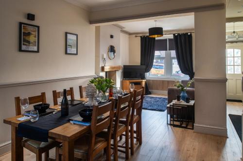 a dining room and living room with a table and chairs at Orme Lodge in Llandudno