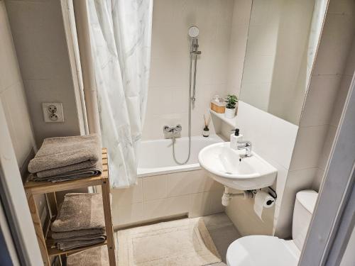 a bathroom with a sink and a toilet and a shower at White Apartment Grzybowska in Warsaw