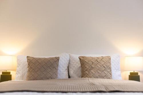 a bedroom with white walls and a bed with two lamps at The Wagon Shed in Sowerby Bridge