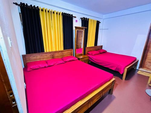 的住宿－Mandaramnuwara Mandarama，红色床单的客房内的两张床
