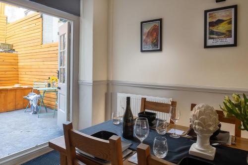 a dining room with a table with wine glasses at Orme Lodge in Llandudno