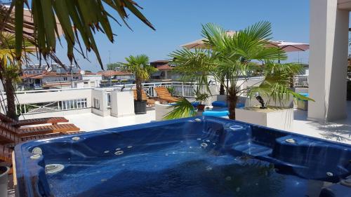 a blue tub on a balcony with palm trees at Harisis Apartments in Olympiaki Akti