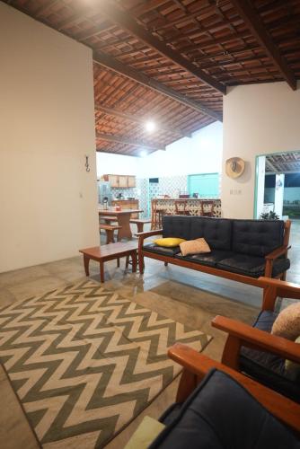 sala de estar con sofá negro y mesas en Villa Romeu, en Fortim