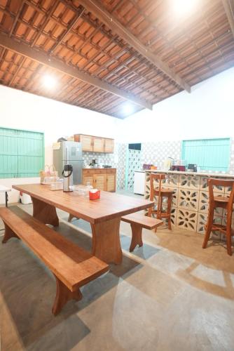 une grande table en bois et des bancs dans une cuisine dans l'établissement Villa Romeu, à Fortim