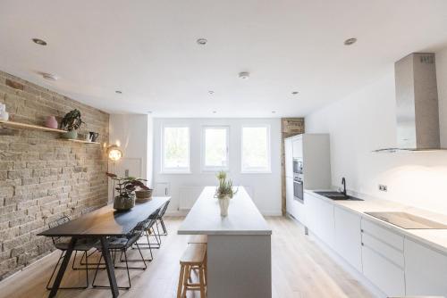 a kitchen with white cabinets and a brick wall at The Wagon Shed in Sowerby Bridge
