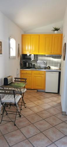 une cuisine avec des armoires jaunes et une table dans l'établissement studio indépendant sur terrasse Toulon, à Toulon
