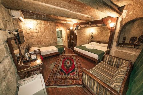 Cette chambre comprend 2 lits et une chaise. dans l'établissement CAPPADOCIA PALACE HOTEL, à Nevşehir