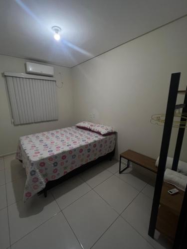 ein kleines Schlafzimmer mit einem Bett und einem Tisch in der Unterkunft Quarto em casa compartilhada in Petrolina