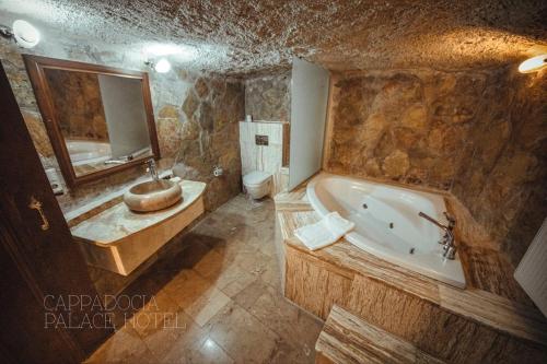 La salle de bains est pourvue d'une baignoire, d'un lavabo et de toilettes. dans l'établissement CAPPADOCIA PALACE HOTEL, à Nevşehir