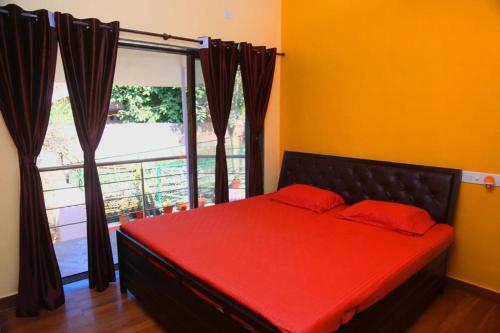 1 cama con almohadas rojas en una habitación con ventana en Dream villa en Lonavala