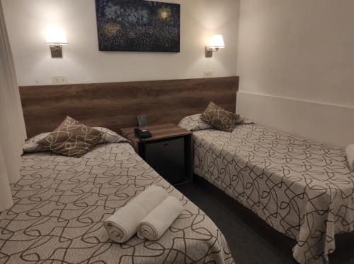 a hotel room with two beds with towels on them at HOTEL ROMA DE TANDIL in Tandil