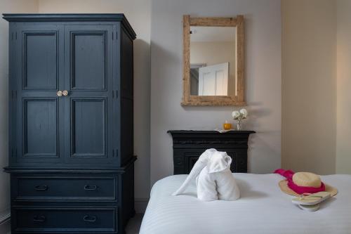 a bedroom with a black dresser and a bed with towels at Orme Lodge in Llandudno