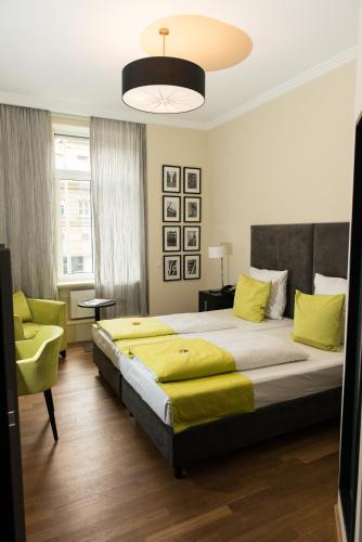 a bedroom with a large bed and a chair at Hotel Hamburger Hof in Frankfurt/Main