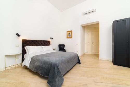 een slaapkamer met een groot bed en een televisie bij One&One in Salerno