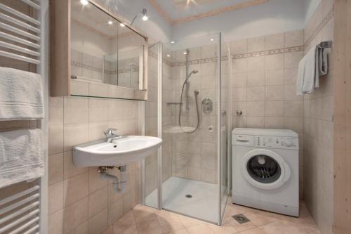 een badkamer met een wastafel en een wasmachine bij Haus Gabi Runggaldier in San Pietro in Laion