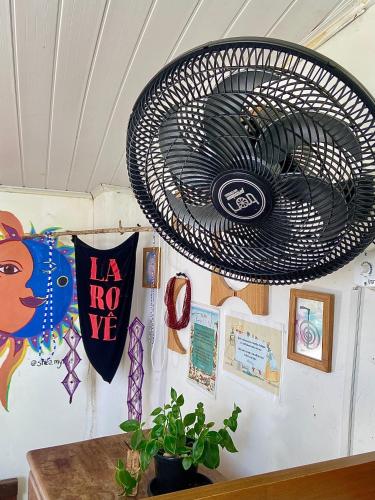 a wall with a black metal fan hanging on it at CasAMARelo Hostel in Salvador