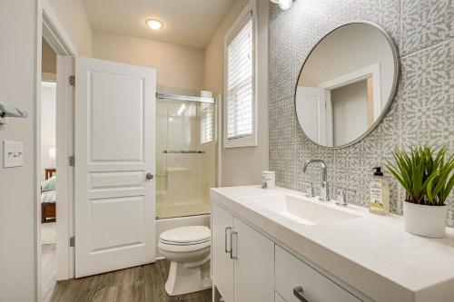 a bathroom with a sink and a toilet and a mirror at Updated Greenville Home with Deck about 1 Mi to Downtown in Greenville