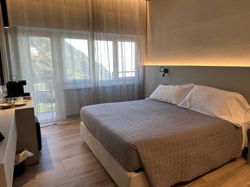 a bedroom with a bed and a large window at The Upper House in Riomaggiore