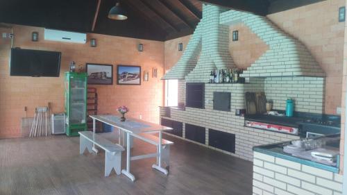 a kitchen with a table and a brick oven at Pousada Tia Zane in Pomerode
