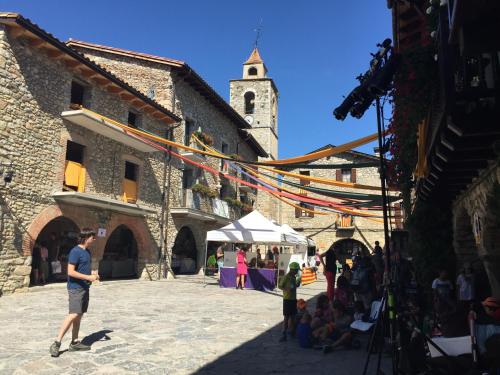 a man standing in a courtyard of a building with a market at La Calma de Bellver in Bellver de Cerdanya 