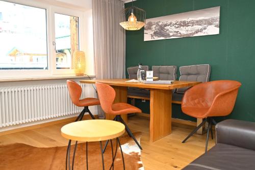 a dining room with a wooden table and chairs at Alp-Chalet in Hirschegg