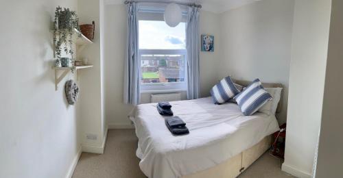 a small bedroom with a bed with a window at Spacious Victorian townhouse with Cathedral views in Lincoln