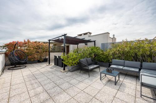a patio with furniture and plants on a roof at Close to Duomo with wonderful terrace in Milan
