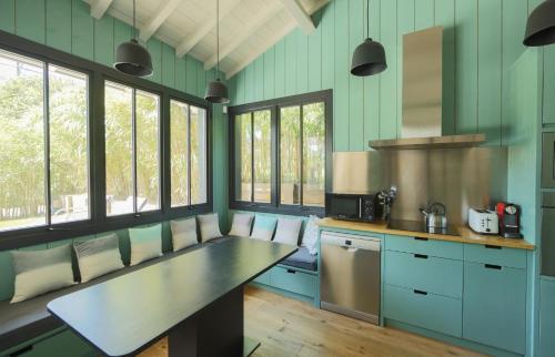 eine Küche mit blauen Wänden und Fenstern sowie einer Theke in der Unterkunft CABANE SOPHIE au CAP FERRET in Cap-Ferret