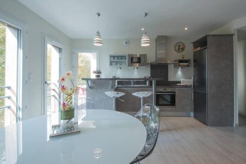 a kitchen with a table and chairs in a kitchen at T2 haut de gamme avec vue Bassin in Andernos-les-Bains