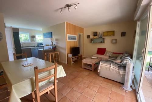 - un salon avec une table et un canapé dans l'établissement VILLA DES ORTOLANS au CAP FERRET, à Cap-Ferret