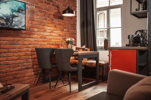 a kitchen with a brick wall and a table and chairs at Gentry11 Rooms&More in Maribor