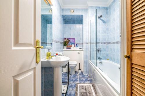 a bathroom with a sink and a toilet and a shower at LiveStay 2BR/2BA with Communal Pool, Sauna & Gym in London