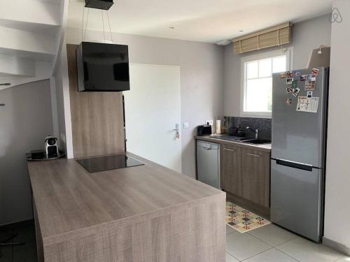 a kitchen with a refrigerator and a counter top at VILLA CARO à ARES - BASSIN D'ARCACHON in Arès