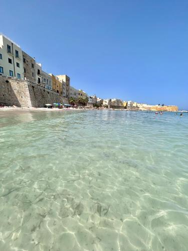 a view of a beach with clear water and buildings at Vicolo 35 Apartments in Trapani