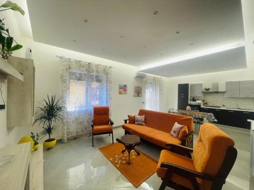 ein Wohnzimmer mit einer Couch und zwei Sesseln in der Unterkunft La Pigna Casa Vacanza in Nicolosi